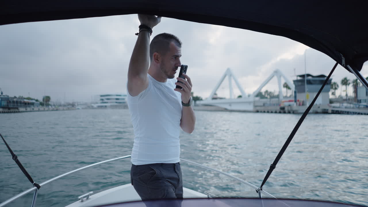 Man on a boat in a marina communicating and relaxing