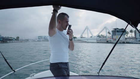 man on a boat in a marina communicating and relaxing