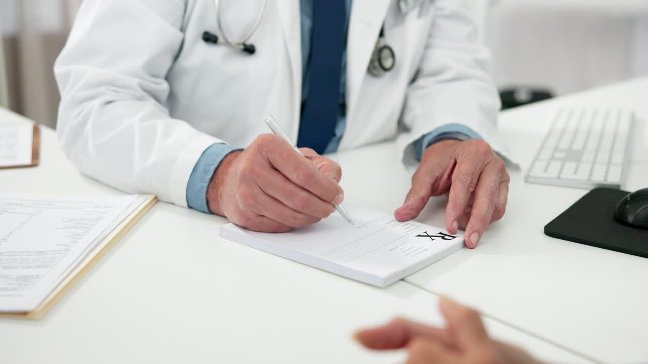 Médico escrevendo uma receita em um bloco de receituário em uma clínica.