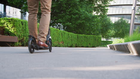 businessman commuting to work through city on scooter