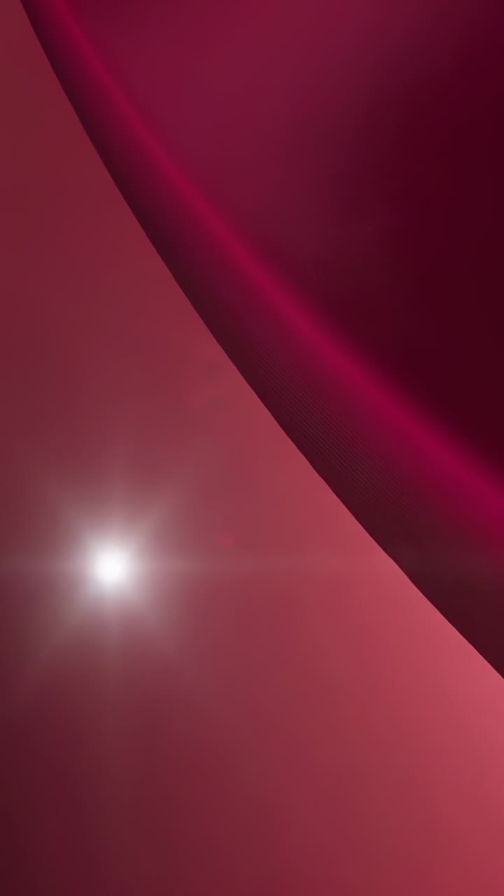 Vertical video: Entering maroon ribbon sweeping to center on gradient, pulsing flare, light streaks