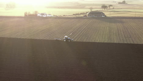 vista aérea de un tractor agrícola arando un campo en aberdeenshire en un día soleado, escocia