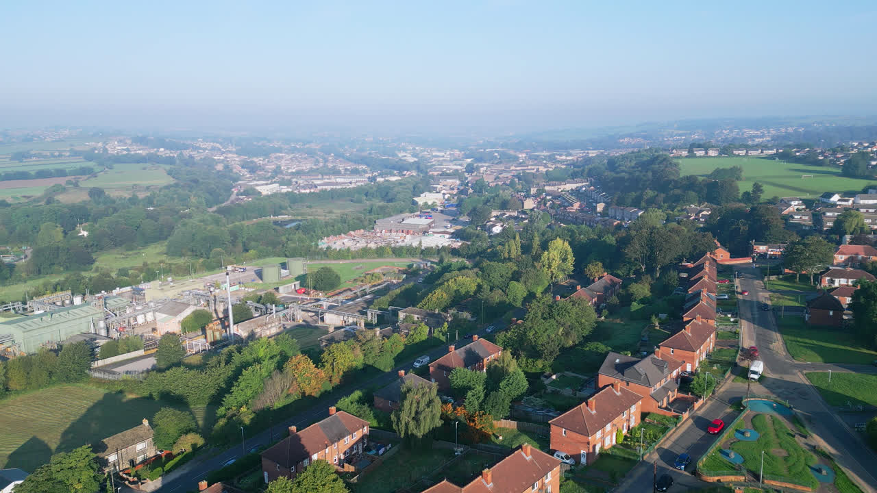 A drone's gaze at Dewsbury Moore Council estate, UK, showcasing red-brick housing and Yorkshire's industry on a sunny day