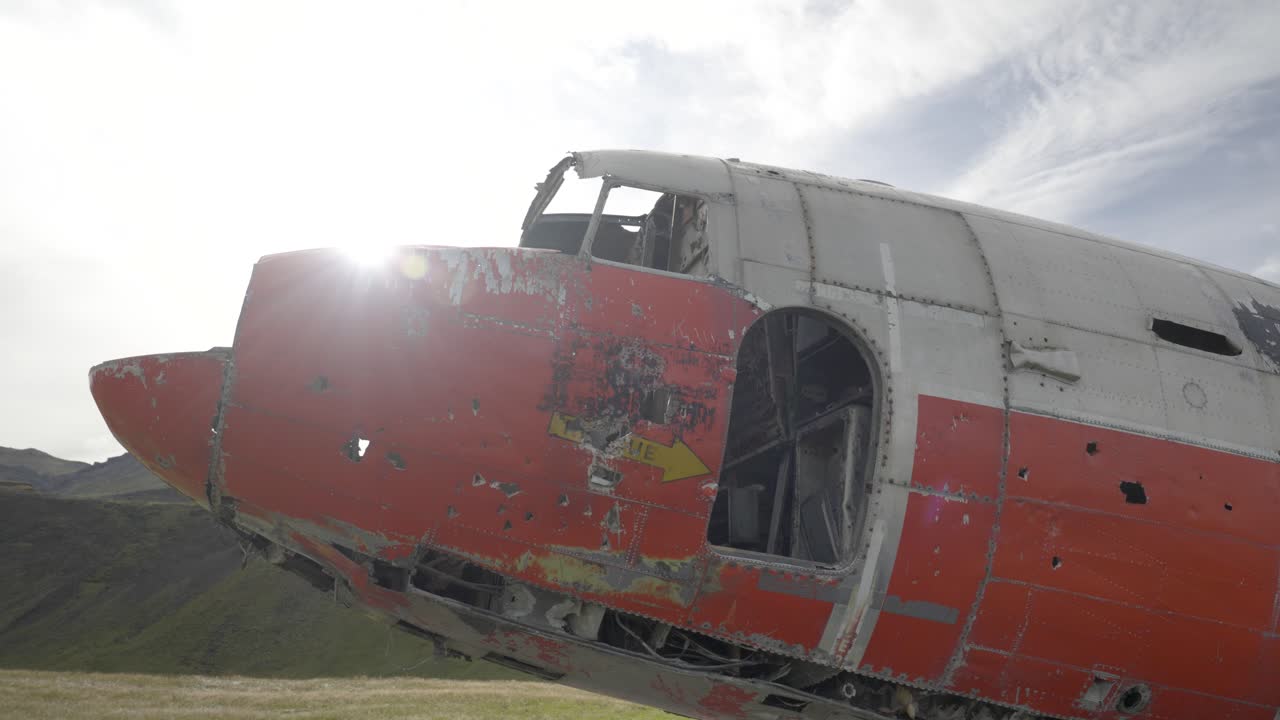 vista lateral del avión estrellado en el paisaje montañoso de islandia