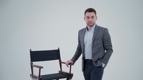 portrait of a stylish man in suit in studio. handsome businessman in grey costume isolated on light background. slow motion.