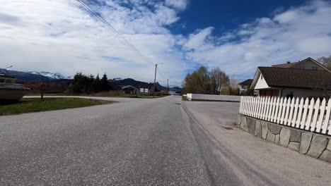 Ciclismo-A-Alta-Velocidad-En-Una-Pequeña-Carretera-A-Través-De-Urbanizaciones-En-Noruega