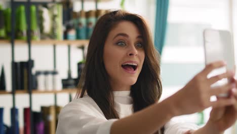 vista de la mano de una mujer hermosa tomando selfies en un salón de peluquería