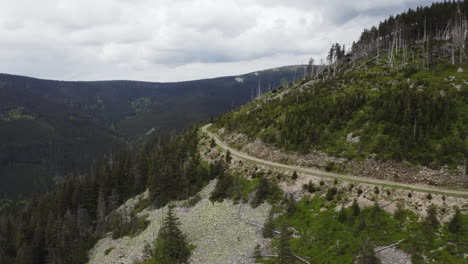 Asphalt-road-bending-in-high-mountains-of-Moravia,-Czechia,-drone-shot