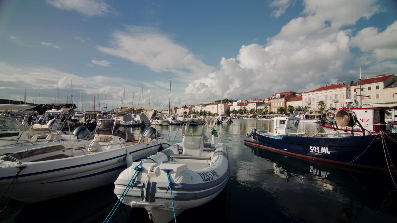 Barche ormeggiate al molo a Mali Losinj, Croazia, galleggiano in acque limpide a mezzogiorno.