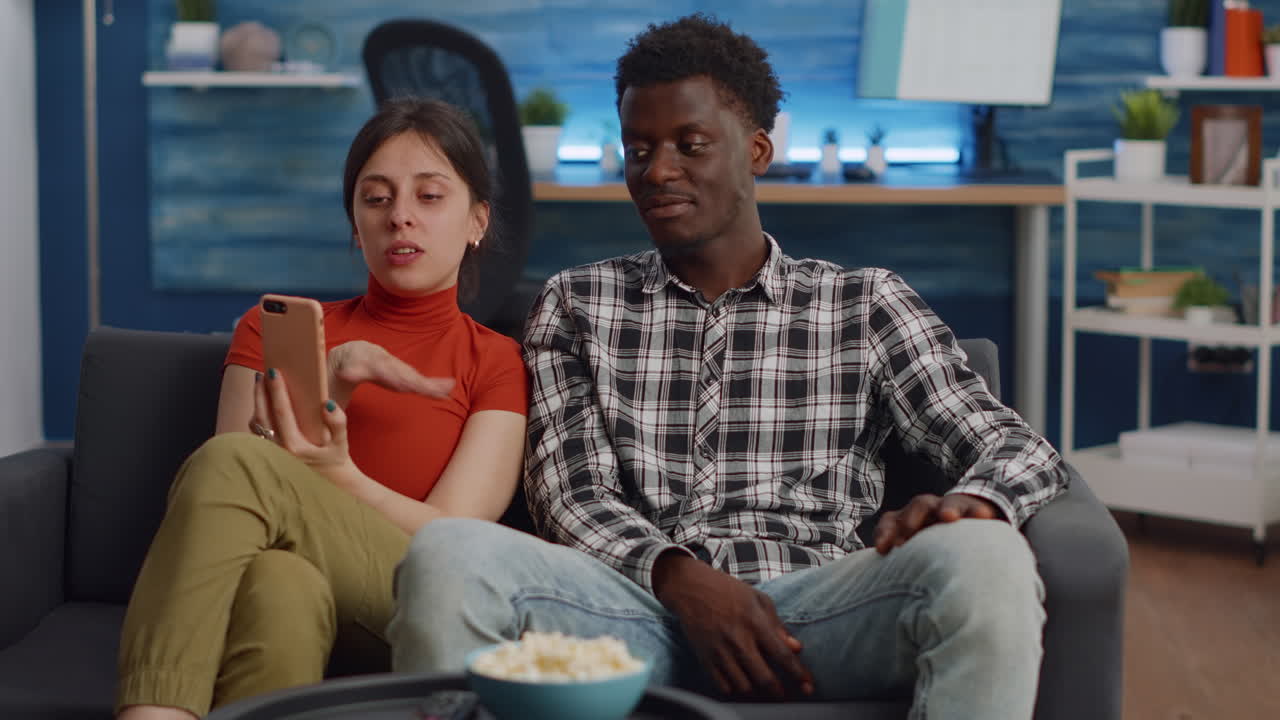 Young interracial couple talking on video call with camera