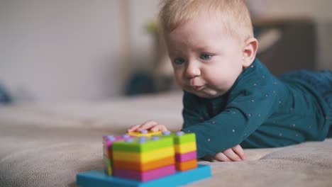 un niño lindo juega con un juguete y su hermana camina en el fondo