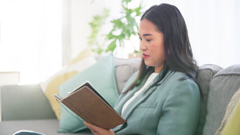 notebook, reading and asian woman on a sofa