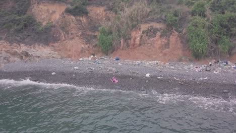 broken plastic chair washed up on beach in hong kong. aerial drone view
