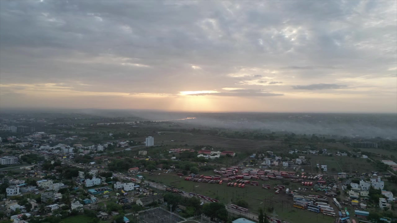 Raggio di sole tra le nuvole: Paesaggio urbano mattutino nebbioso.
