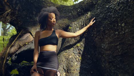 asombroso modelo de cabello natural parado junto a un gran tronco de árbol del árbol de seda de algodón