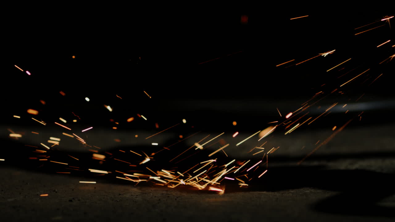 Sparks sizzled and danced in a spectacular display as the tool struck against the metal, creating a mesmerizing shower of fiery particles