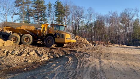 Larger-commercial-dump-truck,-pile-of-dirt-and-stones-for-foundation-materials