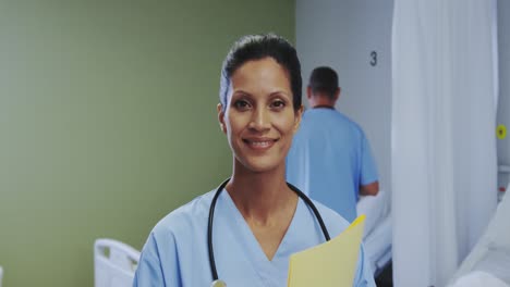 Front-view-of-African-american-female-doctor-looking-at-camera-in-the-ward-at-hospital