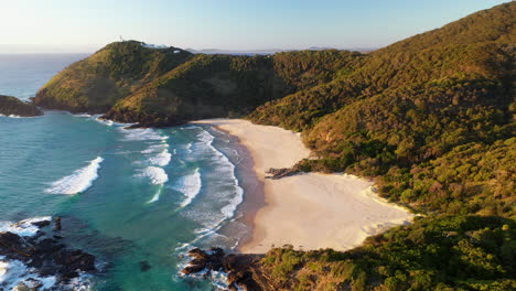 Wide-revealing-drone-shot-of-North-Smoky-Beach,-with-the-Smoky-Cape-Lighthouse-in-background