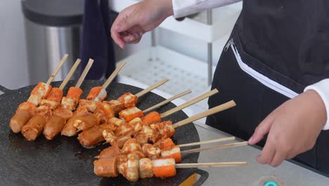 young woman making barbecue suki satay and grilling over a hot frying pan