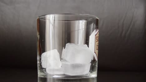 close-up-shot-of-wiskey-being-poured-in-glass-with-ice