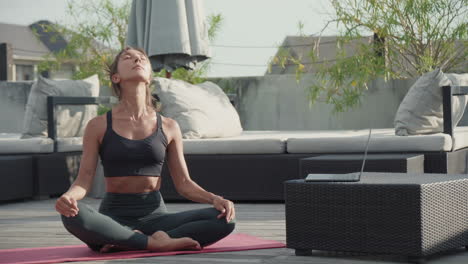 woman doing yoga on roof terrace