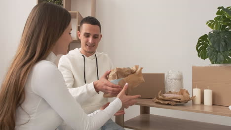 alejar la toma de una pareja feliz mudándose de casa empacando sus pertenencias y abrazándose