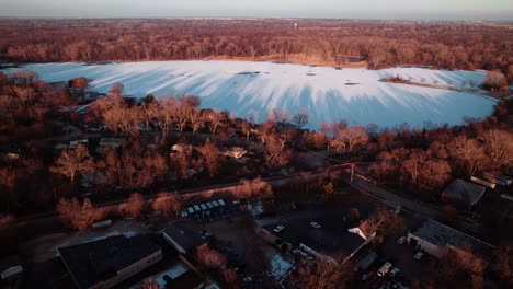 frozen-Minear-Lake-winter-from-Libertyville,-Illinois,-USA-sunset-aerial-4k