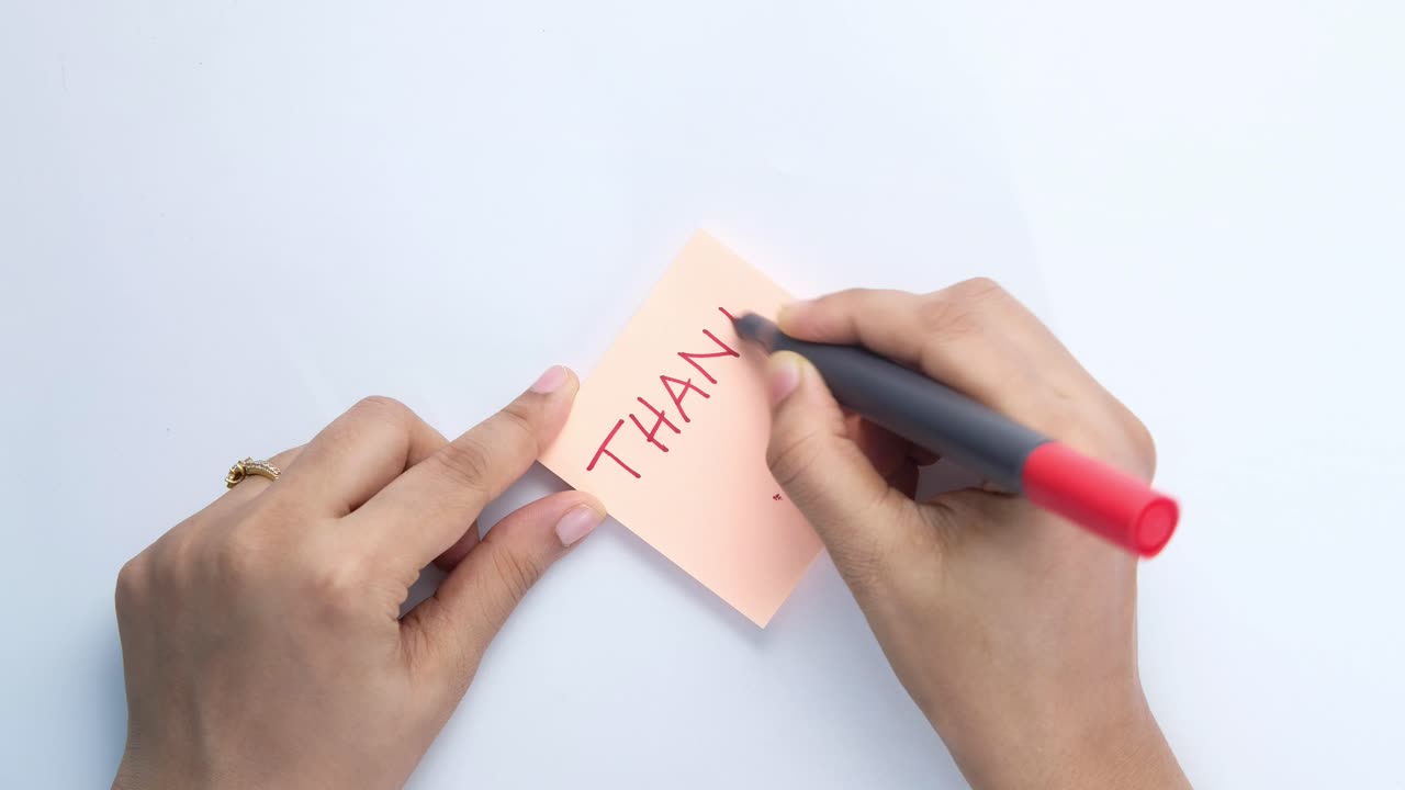 붙여진 메모에 감사 인사를 쓰고 있는 사람