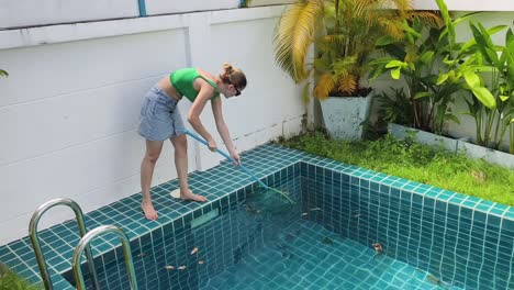 woman cleaning a pool