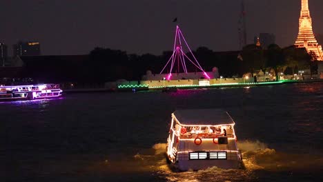 illuminated boat cruising past wat arun temple