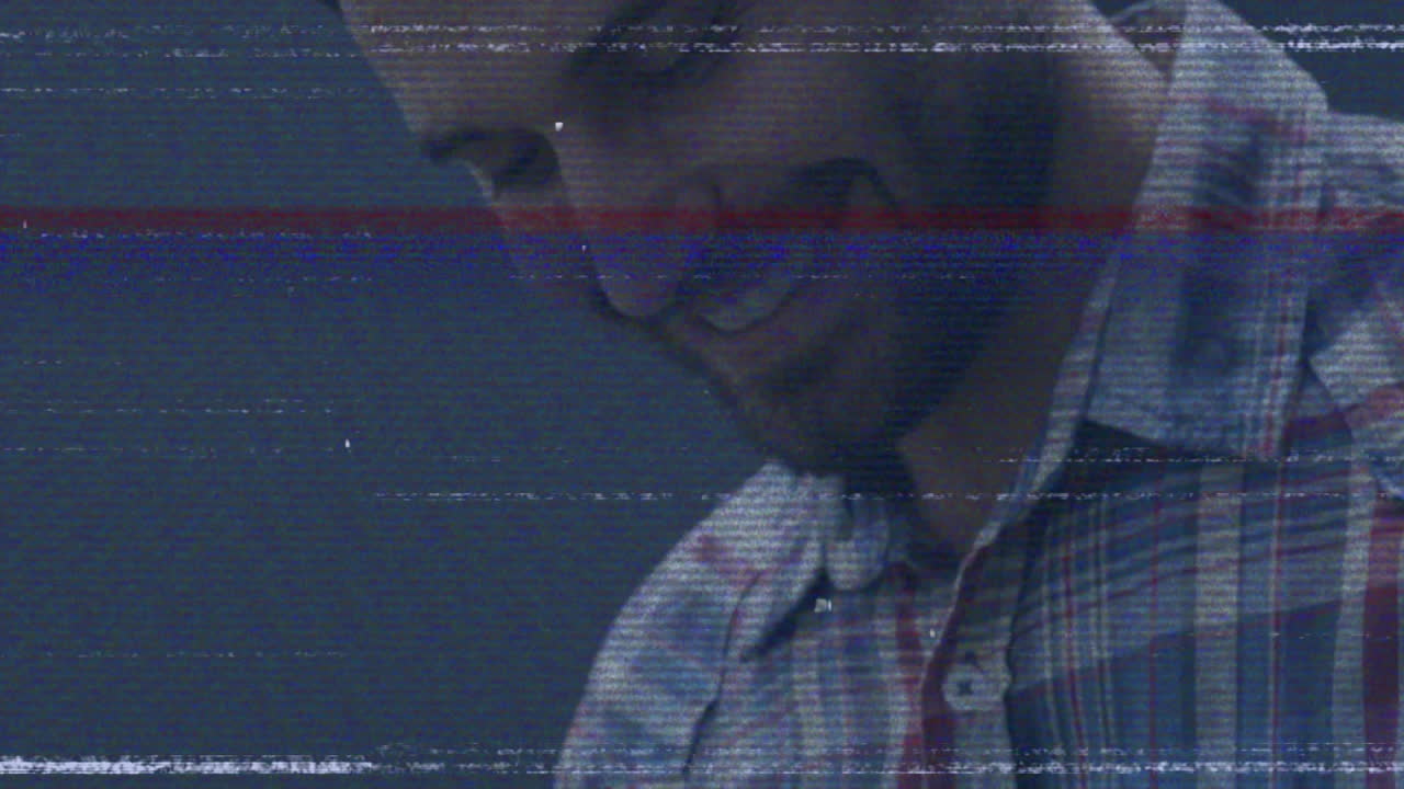 Wearing plaid shirt, man with glitch effect over blue background, creating animation