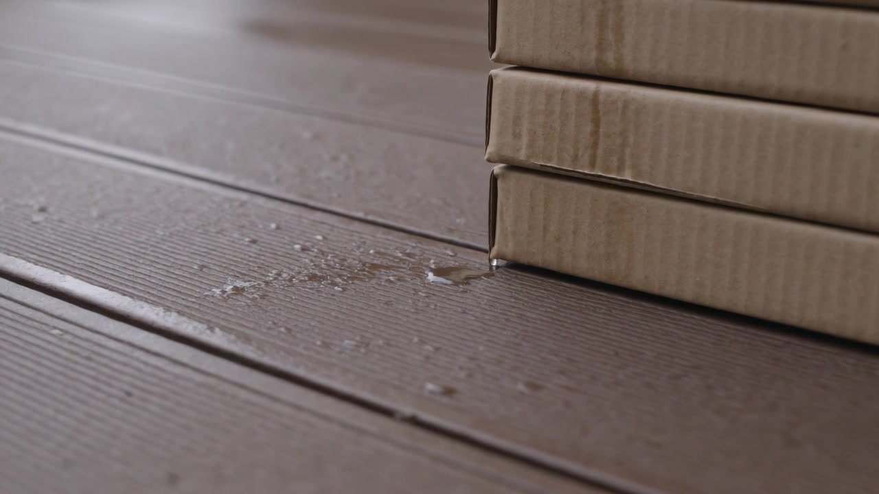 Forming wet spot at base, stacked corrugated boxes leaking beads along grooved deck, copy space