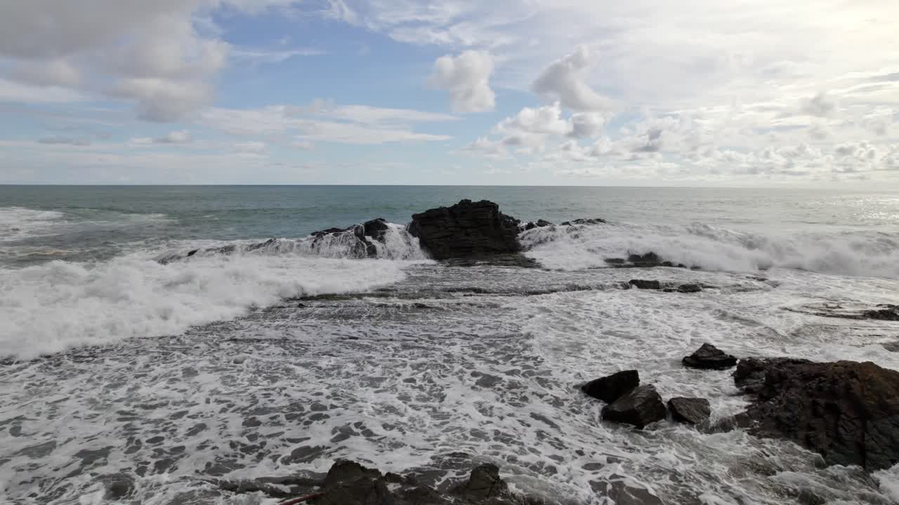 코스타리카 도미니칼리토 해변에서 흐린 날에 바위 해안 근처의 거품 바다 파도의 공중 돌리