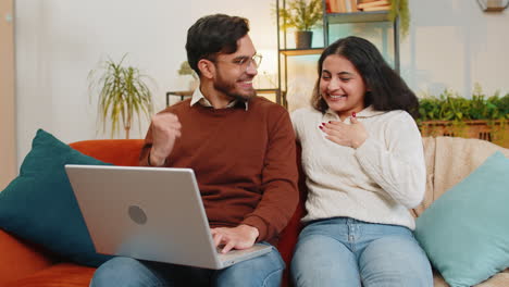 Alegre-Joven-Pareja-De-Familia-India-Hombre-Mujer-Usando-Una-Computadora-Portátil-Y-Sorprendida-Con-El-Correo-Electrónico-Ganando-La-Lotería