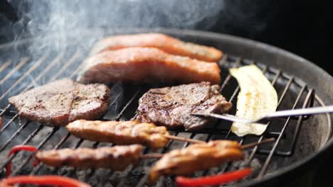 the steak is turned over with the grill tongs medium shot