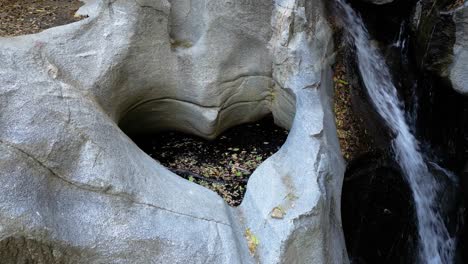 Rotating-Around-Heartrock-in-Crestline-California---Natural-Rock-Formation-with-Flowing-Waterfall