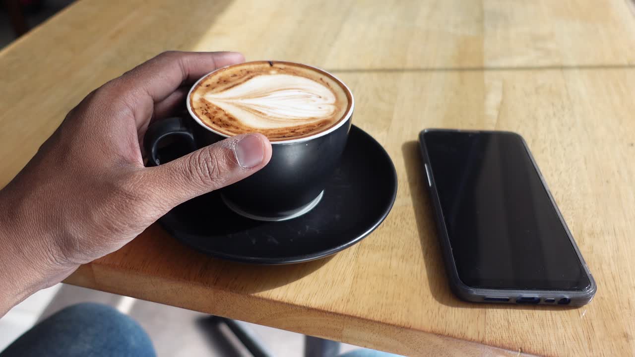 persona disfrutando de un capuchino en un café