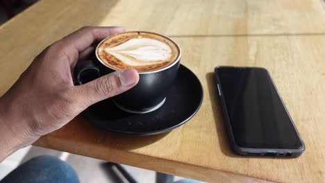 persona disfrutando de un capuchino en un café