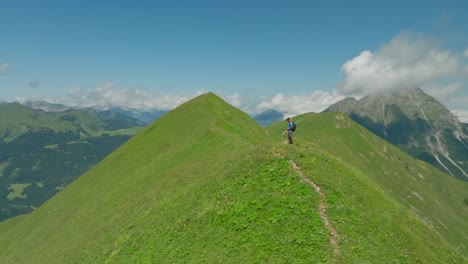 Couple enjoying breathtaking mountain view on green hill, Austria, captured by drone 360 shot
