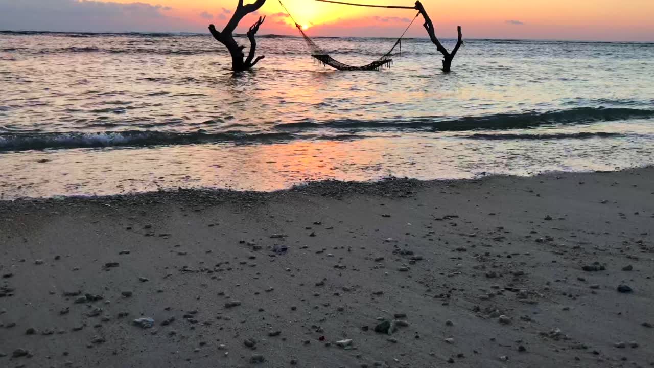 Rede nas Ilhas Gili na água ao pôr do sol, Bali, Indonésia.