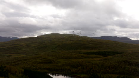 turbinas eólicas giratorias sobre montañas contra un cielo nublado en sortland, noruega.