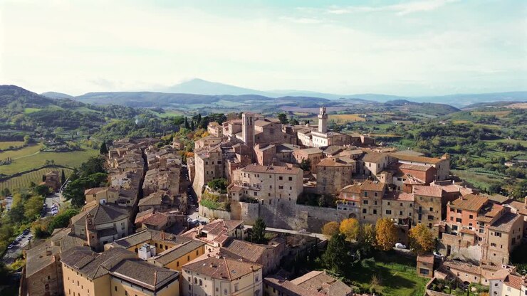 Vista aerea panoramica della città toscana di Montepulciano circondata da vigneti sotto la luce dorata del sole pomeridiano, avvicinamento