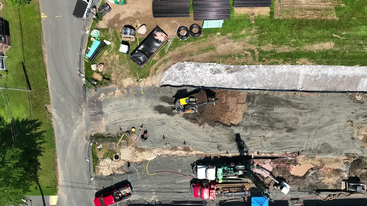 drone de arriba hacia abajo descendiendo en la excavadora de construcción amarilla quitando la suciedad