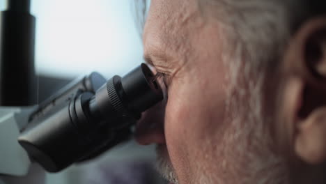 Científico mirando a través del microscopio