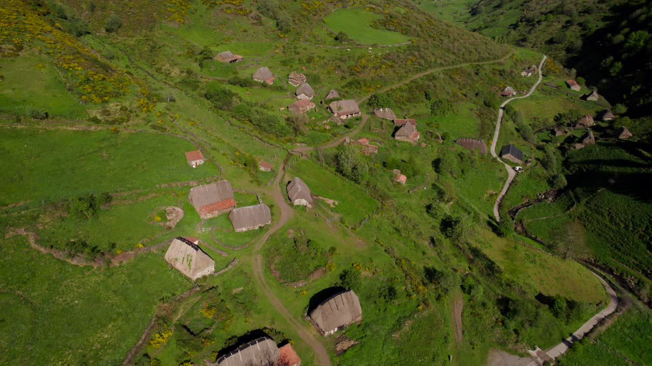 дрон летит над отдаленной сельской деревней, состоящей из хижин для старого переселения