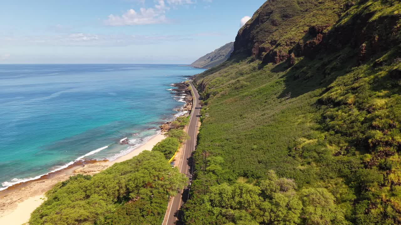 Farrington Highway tra scogliere lussureggianti e oceano tropicale a Oahu, Hawaii, vista aerea.