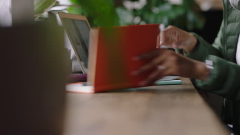 joven mujer afroamericana usando un teléfono inteligente en un café navegando en línea leyendo mensajes de redes sociales escribiendo notas intercambiando ideas para un negocio de inicio bebiendo café