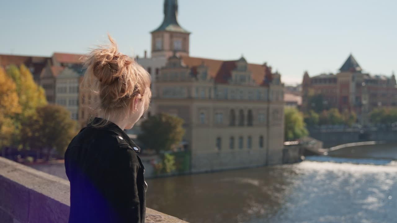 찰스 다리 에서 강 을 바라보면서 태양 으로부터 눈 을 보호 하는 여자