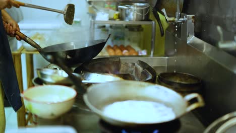 Chef skillfully cooks with a wok in kitchen